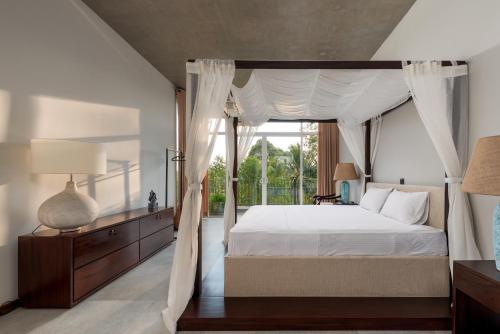 a bedroom with a canopy bed with a window at Hikka Hill Loft in Hikkaduwa