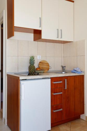 a kitchen with white cabinets and a white refrigerator at Apartments Villa Lili in Tučepi