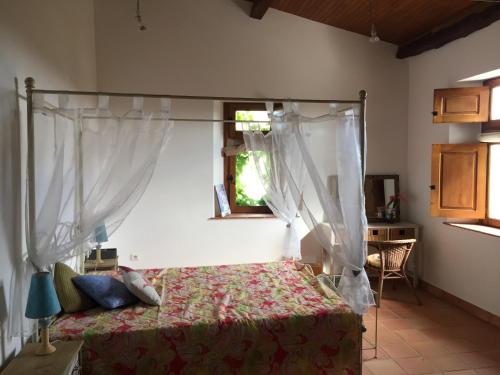 - une chambre avec un lit à baldaquin et une fenêtre dans l'établissement Bastide de charme du Triangle d'Or dans le Tarn, à Fayssac