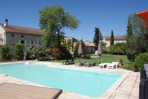 - une piscine dans une cour avec des parasols dans l'établissement Bastide de charme du Triangle d'Or dans le Tarn, à Fayssac