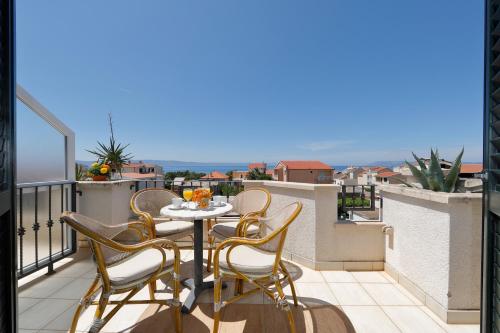 a patio with a table and chairs on a balcony at Apartments Villa Lili in Tučepi