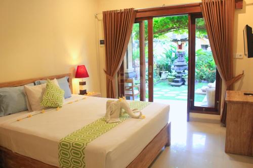 a bedroom with a bed with a stuffed animal on it at CR Tris Rooms Seminyak in Seminyak