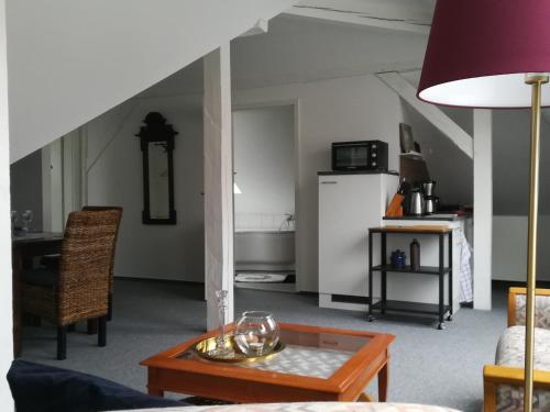 uma sala de estar com uma mesa e uma cozinha em Ferienappartement im Herzen der Stadt em Dessau