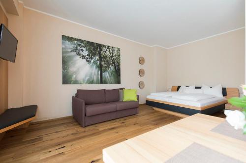 ein Wohnzimmer mit einem Bett und einem Sofa in der Unterkunft Weingut Gsellmann - Wohnen bei Ilse in Gols