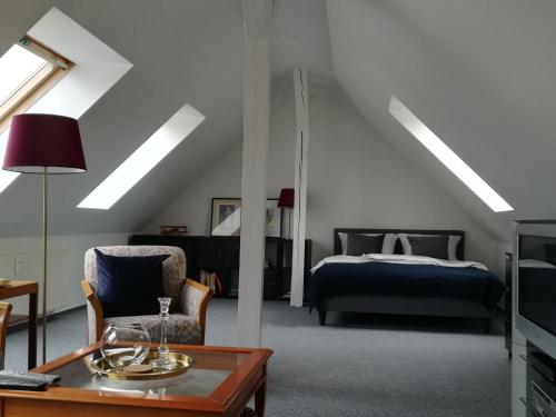 a bedroom with a bed and a chair and a table at Ferienappartement im Herzen der Stadt in Dessau