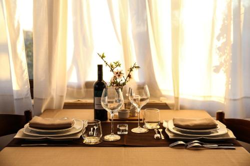 a table with a bottle of wine and glasses at B&B Eyexei Domus in Agrigento