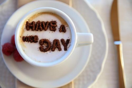 a cup of coffee with the words have a good day written on it at B&B Eyexei Domus in Agrigento