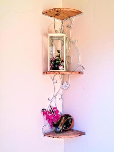 a shelf on a wall with a mirror and flowers at Batumi Wonderland in Batumi