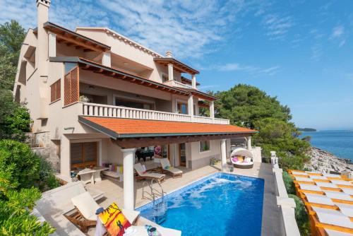 dom z basenem nad oceanem w obiekcie Exceptional Beachfront Holiday Villa on Korčula Island w mieście Prižba