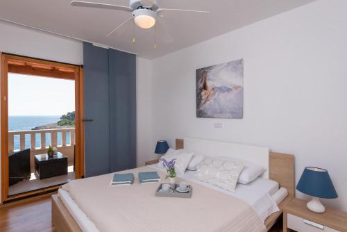 a bedroom with a bed and a view of the ocean at Exceptional Beachfront Holiday Villa on Korčula Island in Prizba