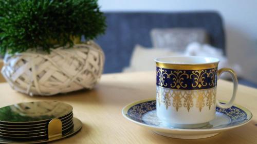 eine Kaffeetasse und ein Teller auf dem Tisch in der Unterkunft Apartamenty siostra i siostra in Łaziska
