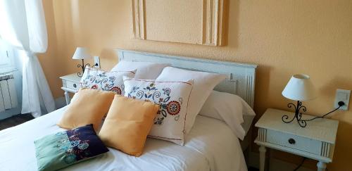a bedroom with a bed with pillows on it at Chambres d'hôtes et Roulotte Au Bonheur Du Parc in Le Breuil