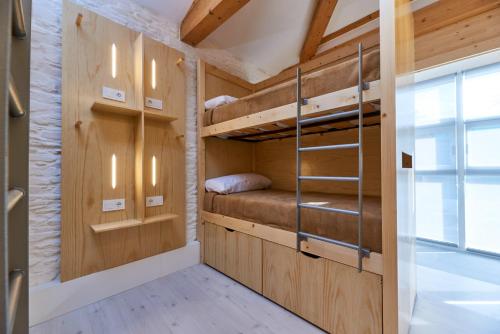 a room with bunk beds and a window at Albergue San Francisco in Arzúa