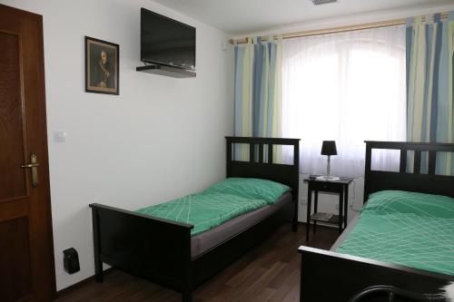 two beds in a small room with a window at Ubytování pod Pálavou in Horní Věstonice
