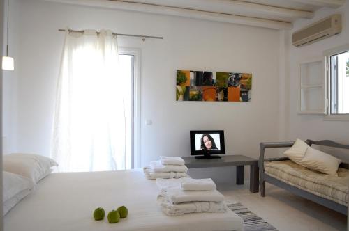 a white room with a bed and a table with towels at Kapetan Tasos Suites in Pollonia