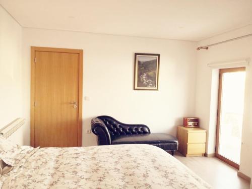 a bedroom with a bed and a chair at Isabel do Couto - casa de charme in Castro Daire