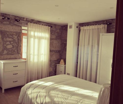 a bedroom with a white bed and a window at Isabel do Couto - casa de charme in Castro Daire