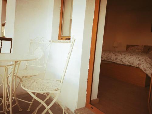 a room with a table and chairs and a bed at Isabel do Couto - casa de charme in Castro Daire