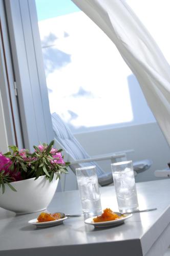a table with plates of food and glasses of water at Kapetan Tasos Suites in Pollonia