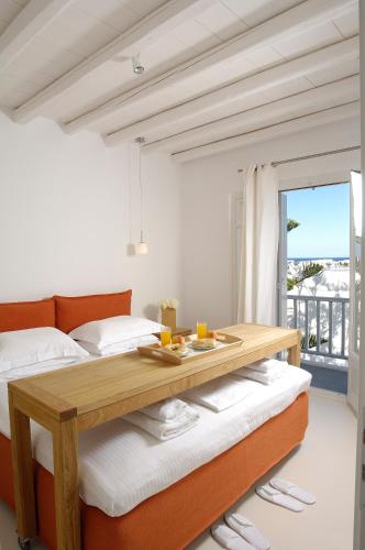 a bedroom with a bed and a wooden table at Kapetan Tasos Suites in Pollonia