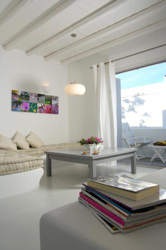 a living room with a table and a couch at Kapetan Tasos Suites in Pollonia