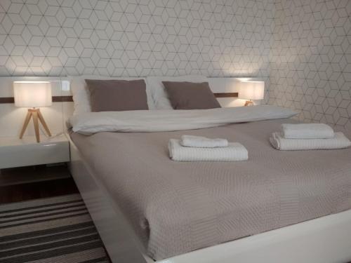a white bed with two towels and two lamps on it at Anielewicza 9 in Warsaw