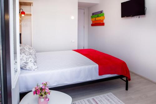 a bedroom with a bed with a red blanket on it at NAIKE in Tbilisi City