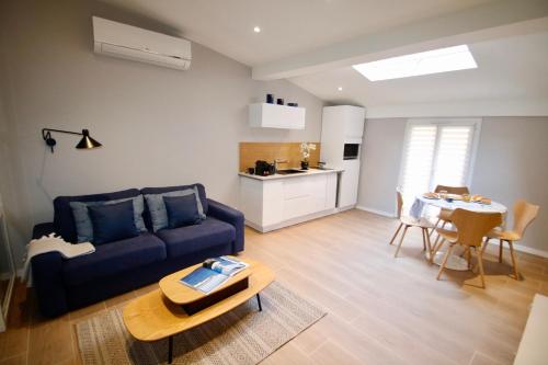 un salon avec un canapé bleu et une table dans l'établissement WAVEBNB All Confort, central, parking, à Nice