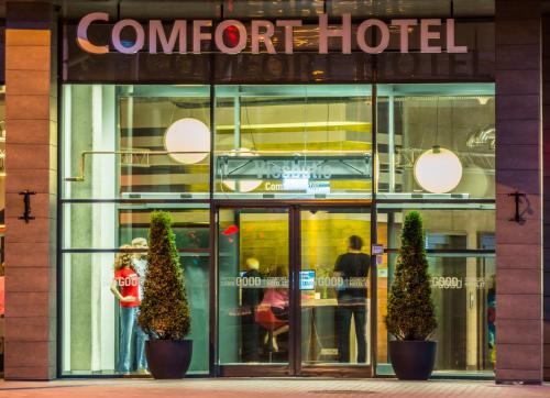 a store front of a corner hotel with two plants in front at Comfort Hotel LT - Rock 'n' Roll Vilnius in Vilnius