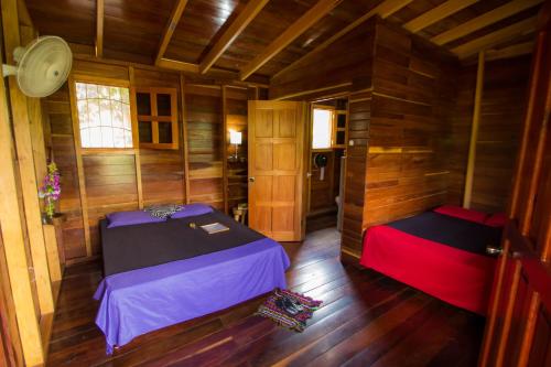 an empty room with two beds in a cabin at Alice Guesthouse in El Remate