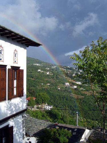 Un arcobaleno nel cielo con una casa di Archontiko Repana - Makrinitsa Stone Retreat a Makrinítsa
