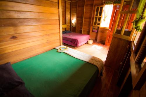 a small room with two beds in a cabin at Alice Guesthouse in El Remate