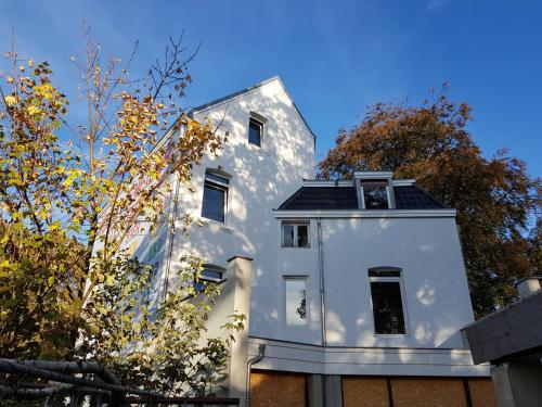a white house with a black roof at B&B The Project in Heerlen