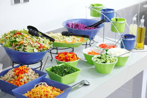 a buffet with bowls of different types of food at Ein Harod Country Lodge in ‘En H̱arod