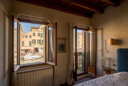 1 Schlafzimmer mit 2 Fenstern und Stadtblick in der Unterkunft Casa Agostina in Venedig