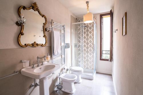 ein Badezimmer mit einem Waschbecken, einem WC und einem Spiegel in der Unterkunft Casa Agostina in Venedig