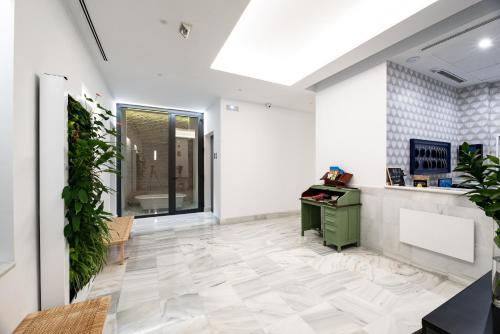 an empty office with a green desk and plants at Uma Suites Parada del Marqués in Seville