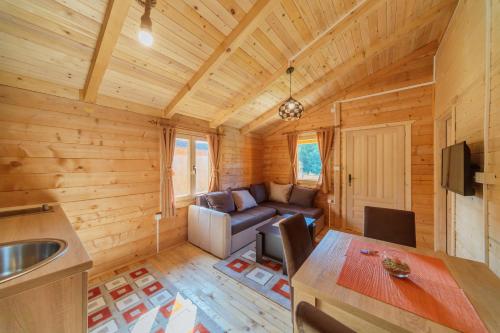 a kitchen and living room of a log cabin at Orahovo Cottages in Virpazar
