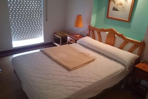 een slaapkamer met een bed en een lamp op een tafel bij se alquila piso céntrico en Sanxenxo c/garaje in Sanxenxo