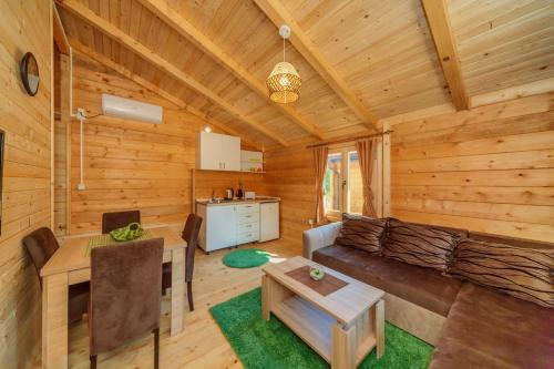 a living room and kitchen in a log cabin at Orahovo Cottages in Virpazar