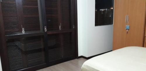 a bedroom with black shuttered windows and a bed at Residencial Franca Garopaba in Garopaba