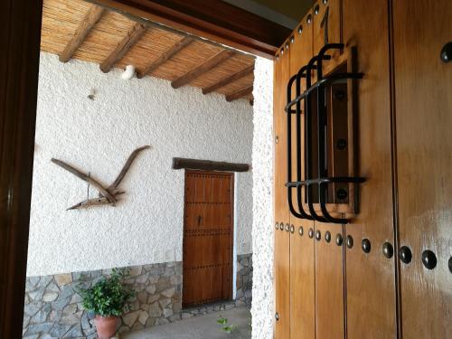een klok aan de zijkant van een gebouw met een deur bij Alojamientos Rurales Las Eras in Granada