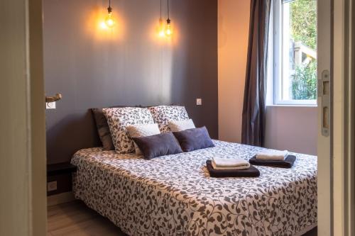 ein Schlafzimmer mit einem Bett mit zwei Handtüchern darauf in der Unterkunft appartement le carnel in Lorient