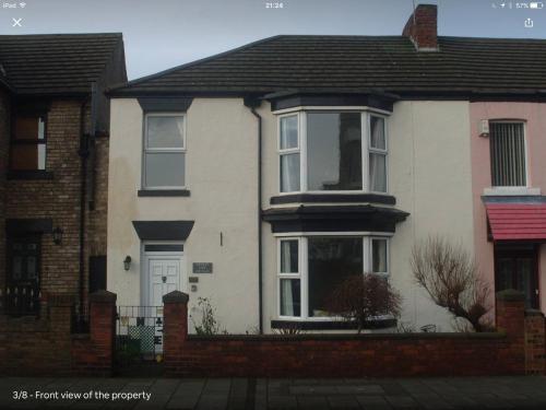 a white house with a black roof at Cricket View cottage in Redcar