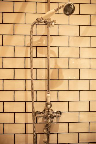 La salle de bains est pourvue d'une douche et d'un mur en briques blanches. dans l'établissement appartement le carnel, à Lorient