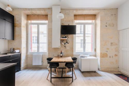 une cuisine avec une table et des chaises dans une pièce dans l'établissement Le COSY - Rue Ausone, à Bordeaux