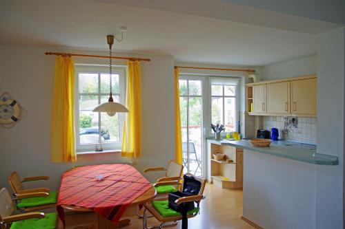 a kitchen with yellow curtains and a table and chairs at Bernsteinhaus Wohnung Usedom in Kolpinsee