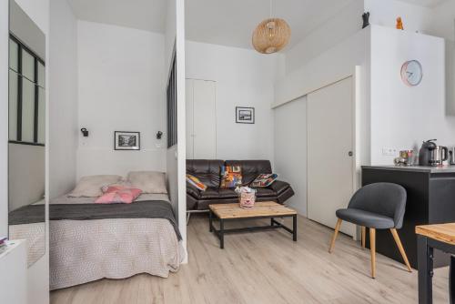 Cette chambre comprend un lit, un canapé et une table. dans l'établissement Le COSY - Rue Ausone, à Bordeaux