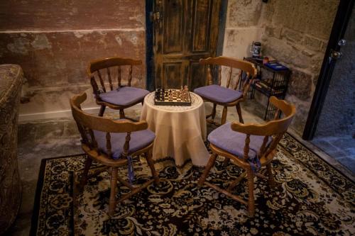 a room with four chairs and a table with a chessboard at Albergue Convento Del Camino in Tui