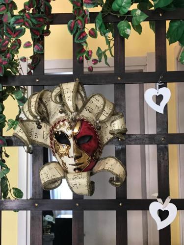 a mask is hanging on a fence at La Casa di Isabella Loreto in Loreto